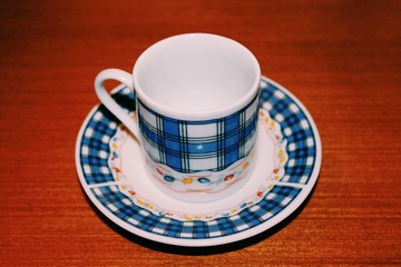 Vintage cup of coffee with a plate on wooden background 