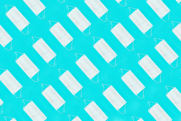 Pattern of face medical masks on blue background. Protection from coronavirus. Top view. Flat lay.