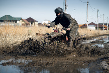Biker riding quad bike on dirty countryside road. © Dmitriy