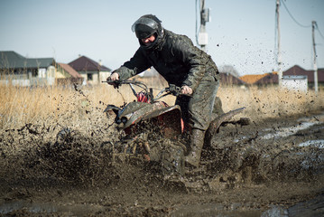 Biker riding quad bike on dirty countryside road. © Dmitriy
