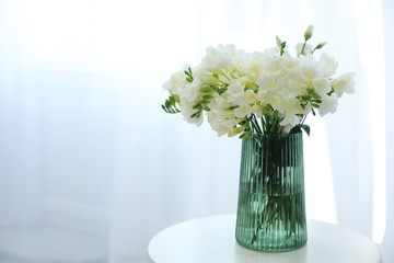 Beautiful bouquet with fresh freesia flowers on table indoors. Space for text