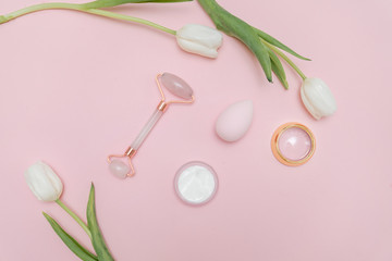 Beauty make up products on a pastel pink background with white tulips. Top view. beauty blog content, fresh blog background. 