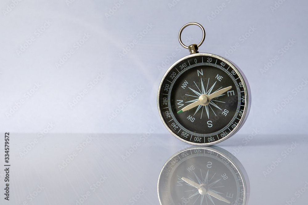 Wall mural compass on light background with copy space using as direction