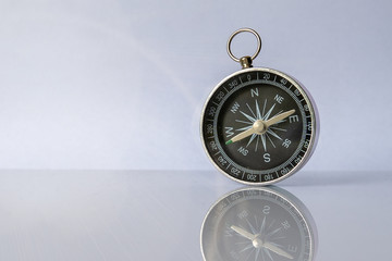 Compass on light background with copy space using as direction © andyborodaty