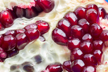 Ripe sliced pomegranate with red berries close-up