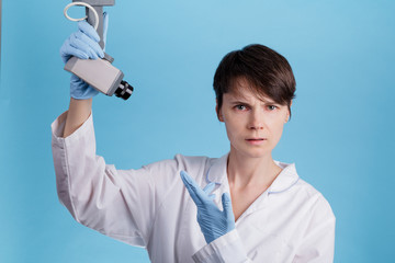 portrait of a young Caucasian female doctor looking at a CCTV camera as an idea of monitoring doctors at work