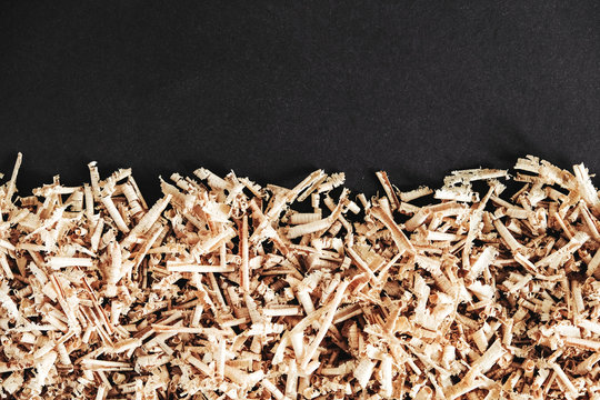 Wood Shavings On Black Background. Background Of Fresh Wood Shavings. Copy, Empty Space For Text