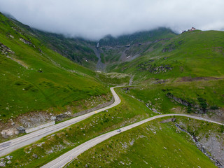 Fototapeta premium Romania. Fagaras mountain range. Mountain highway Transfagarash. One of the most beautiful roads in the world. Popular tourist route. Drone. Aerial view