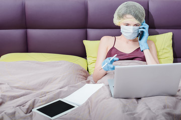 self-isolation and work at home with covid-19 coronavirus. a girl in protective gloves, a mask and...