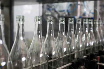 Empty bottles of wine on the mobile line. Wine bottling at a local winery