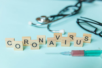 Text phrase Coronavirus syringe eyeglasses and stethoscope on blue pastel background. Novel coronavirus 2019-nCoV MERS-Cov covid-19 middle East respiratory syndrome coronavirus virus vaccine concept.