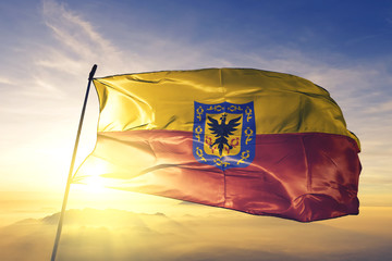 Bogota of Colombia flag waving on the top sunrise mist fog