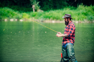 Bearded fisher. Man fishing. Perfect weekend. Fishing skills. Fisher fishing equipment. Active sunny day. Good profit. Bearded fisher in water. Adventures. Young man happy. Nice day. Hunting.