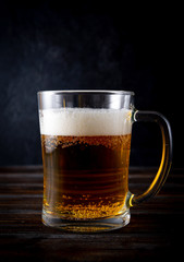 light beer, 1 beer mug on a dark wooden background, alcoholic drink