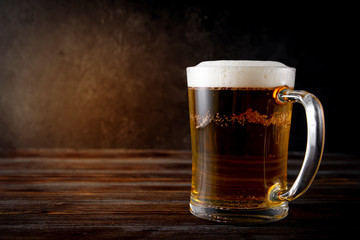  alcoholic drink , light beer, beer mug on a dark wooden background,