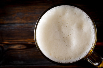 white foam of light beer on a dark background, top view