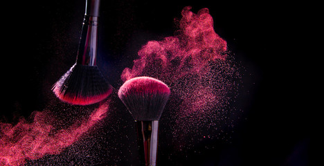 Colorful explosion on makeup brushes on a black background - 334586713