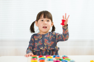 Obraz na płótnie Canvas toddler girl learning letter blocks for homeschooling