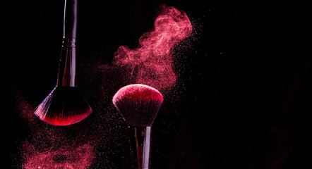 Colorful explosion on makeup brushes on a black background