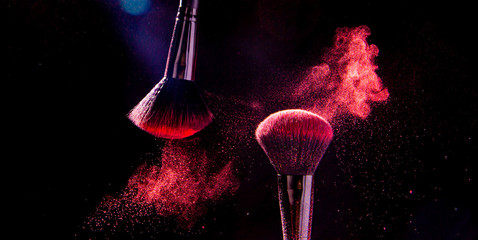 Colorful explosion on makeup brushes on a black background