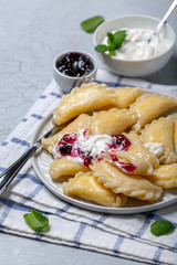 Homemade dumplings with berry sour cream sauce.