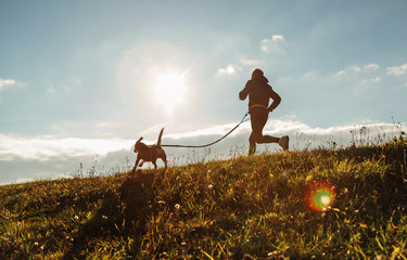Man runing with his beagle dog at sunny morning. Healthy lifestyle and Canicross exercises jogging...
