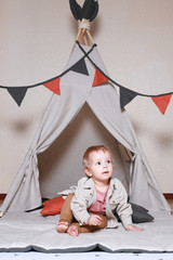 Cute little boy playing in a teepee