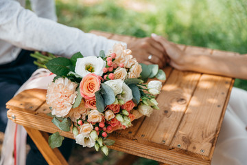 Romantic flower bouquet and two people's hand in hand on background 
