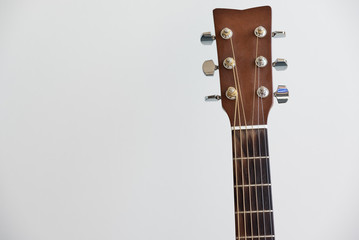 Guitar fretboard close-up, view of the neck of the guitar and strings on white background. Acoustic...