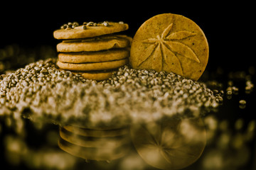 Medical Cannabis Seeds and CBD Cannabis Cookies on the black mirroring background.