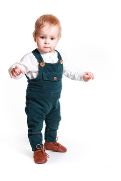 A One-year-old Boy In A Green Jumpsuit