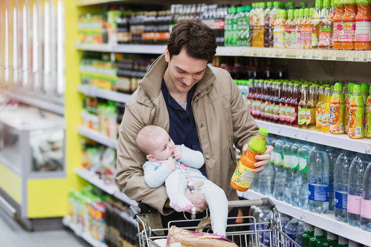Father with baby daughter shopping in supermarket
