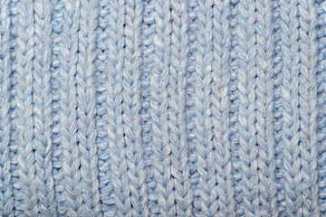Blue knitted wool fabric background. Very warm natural knitwear handmade