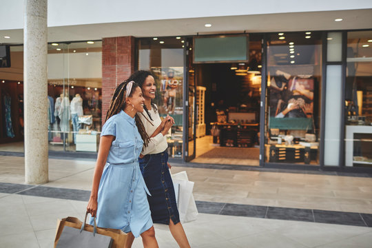 Happy women friends shopping in mall