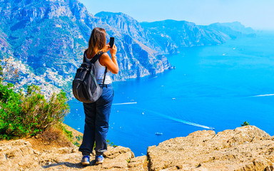 Woman taking photos of Path of Gods on Tyrrhenian sea reflex