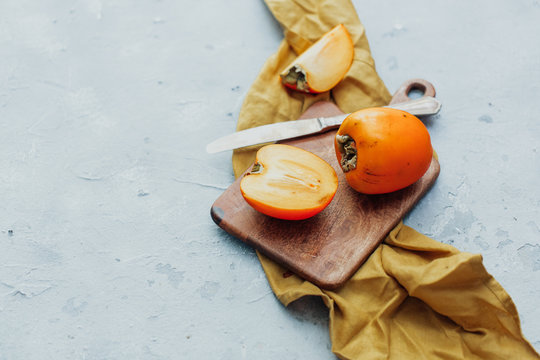 Fresh whole persimmon on wooden background
