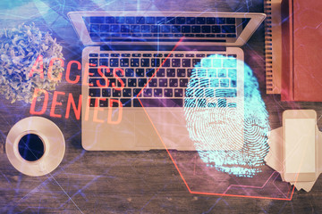 Finger print over computer on the desktop background. Top view. Double exposure. Concept of securitization.