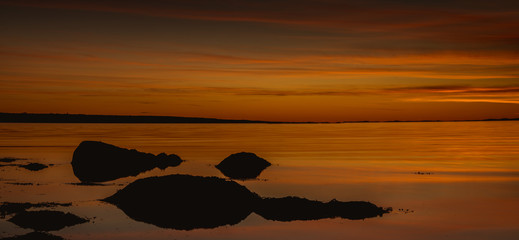 Złota godzina nad skalistym wybrzeżem podczas zachodu słońca w Parku Narodowym Ytre Hvaler w Norwegii - obrazy, fototapety, plakaty