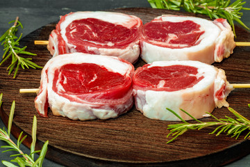 fresh meat with ingredients for cooking on dark background, close up