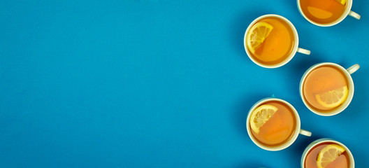 cups and saucers, lemon tea, place for text, top view, warming vitamin drink