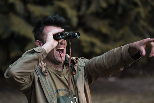 Portrait Of Young Man In The Forest With Binoculars