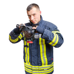 Fototapeta premium young caucasian fireman in uniform puts full facepiece respirator over his head.