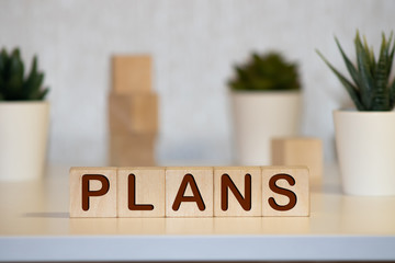 Plans word on table background. Resolution, strategy, solution, goal, business