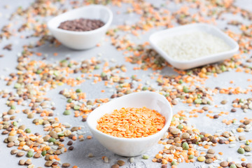 Different types of cereal grains groats in white ceramic bowls. Food background. Top view.