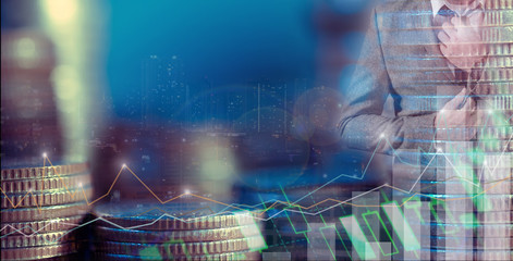 Double exposure of businessman using the tablet with cityscape and financial graph on blurred building background, Business Trading concept