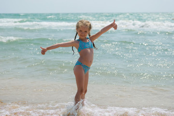Fototapeta na wymiar Child in on the ocean. Little girl on the beach.