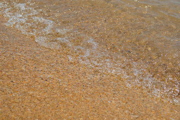 Fototapeta na wymiar Waves are rolling on a sand sea beach.