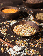 White rice and different types of lentil, dark brown concrete background. Agricultural product concept.