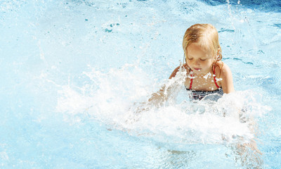 Fototapeta na wymiar Little girl having fun time in the Swimming pool, Summer time, Vacation