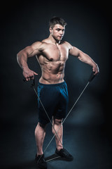 Fototapeta na wymiar Sexy young athlete posing on a black background in the Studio. Fitness, bodybuilding